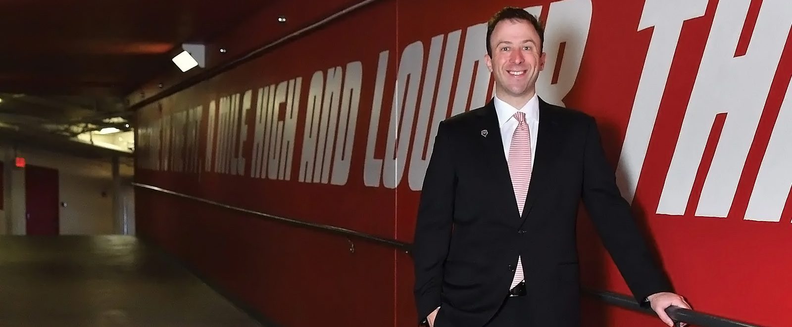 UNM men's basketball coach wearing a suit in the hallway of the Pit arena