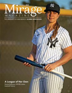 UNM alum Rachel Balkovec stands in the sunlight holding a baseball bat in full New York Yankee attire