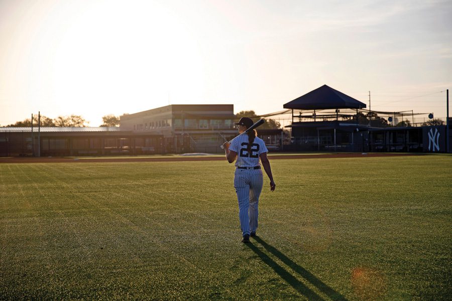 Wearing number 22 Rachel walks toward home plate while the sun sets