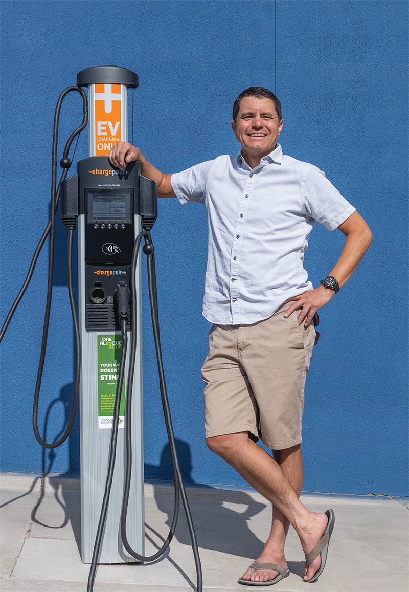Doug Campell poses with electric vehicle charging station