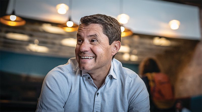 Doug Campbell in blue polo shirt with soft lighting behind