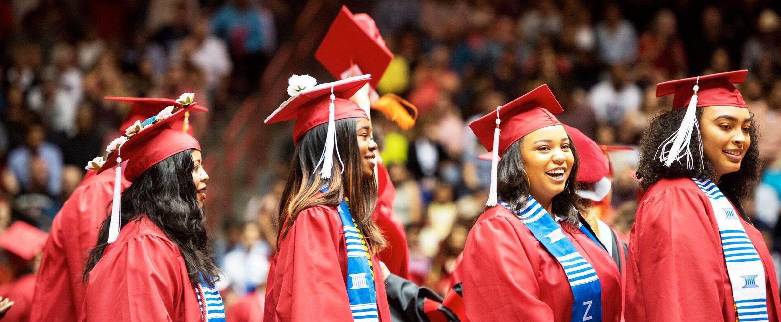 graduates four UNM grads smiling at ceremony