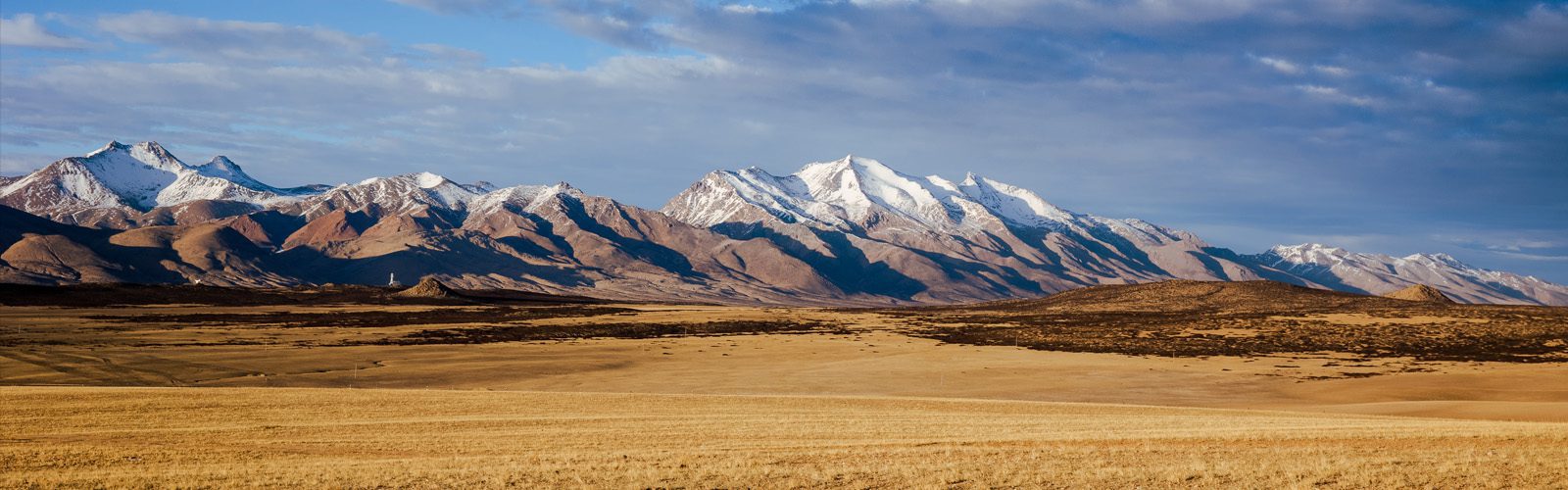 dry tundra with snow dusted peaks in the distance