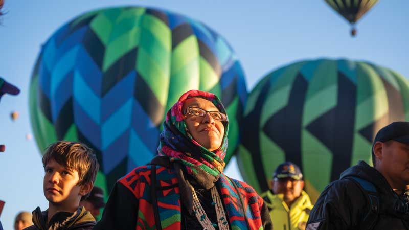 Richelle Montoya with hot air balloons behind her